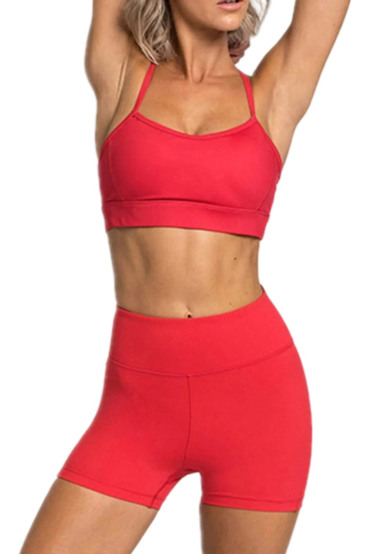 Confident model posing in a fitness center wearing the red matching activewear set for gym workouts.