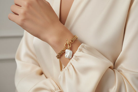 Brinker + Eliza Penny Bracelet styled with a luxury cream silk blouse, embodying the 2026 quiet luxury aesthetic.