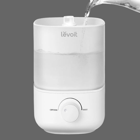 Pouring water into the LEVOIT Classic 160 white humidifier, highlighting its easy top-fill design.