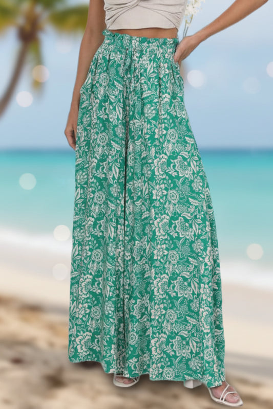 YOCUR High-Waisted Wide Pants, A02 - Front view of green floral print with a blurred Miami beach view behind.